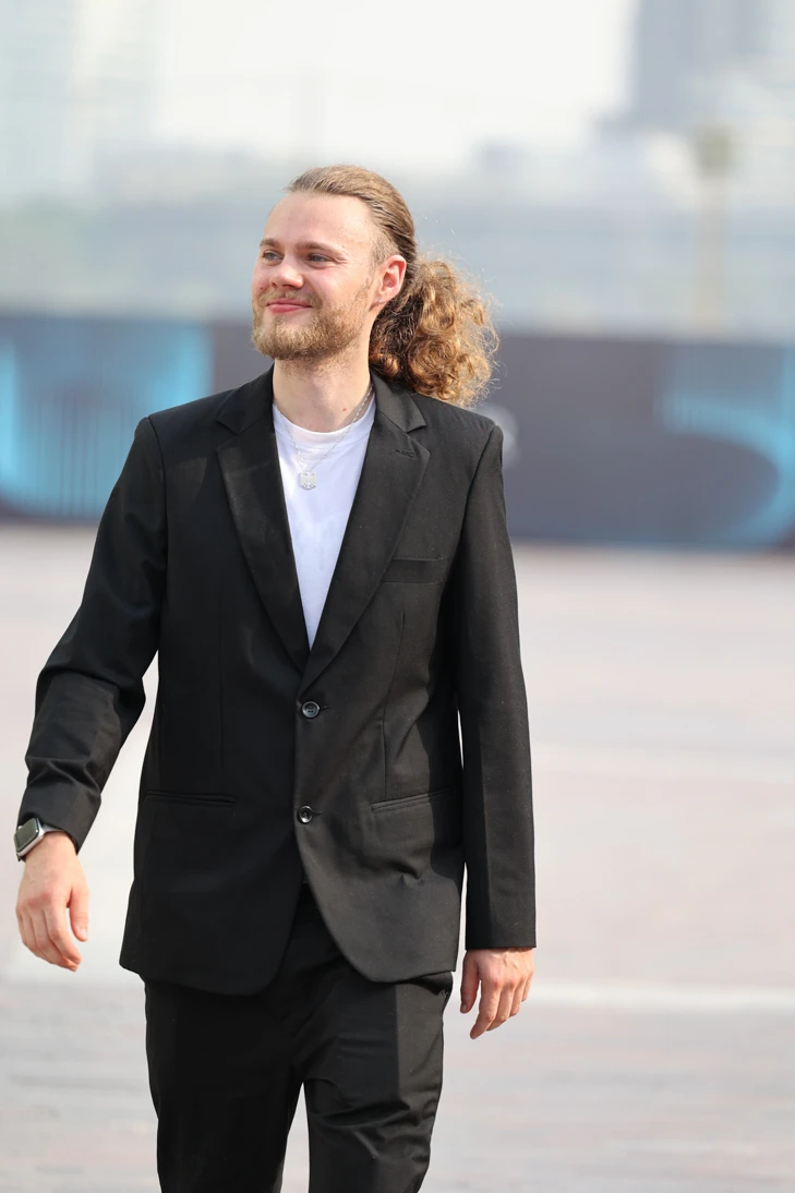 Wilhelm Treffer walking in a black blazer, with both arms visible